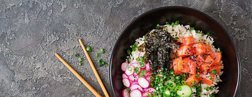 Poké bowl met volle rijst, zalm en knapperige groentjes
