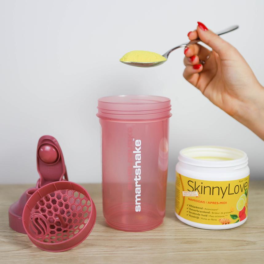 Een plastic shaker met een lepel skinny love fatburner